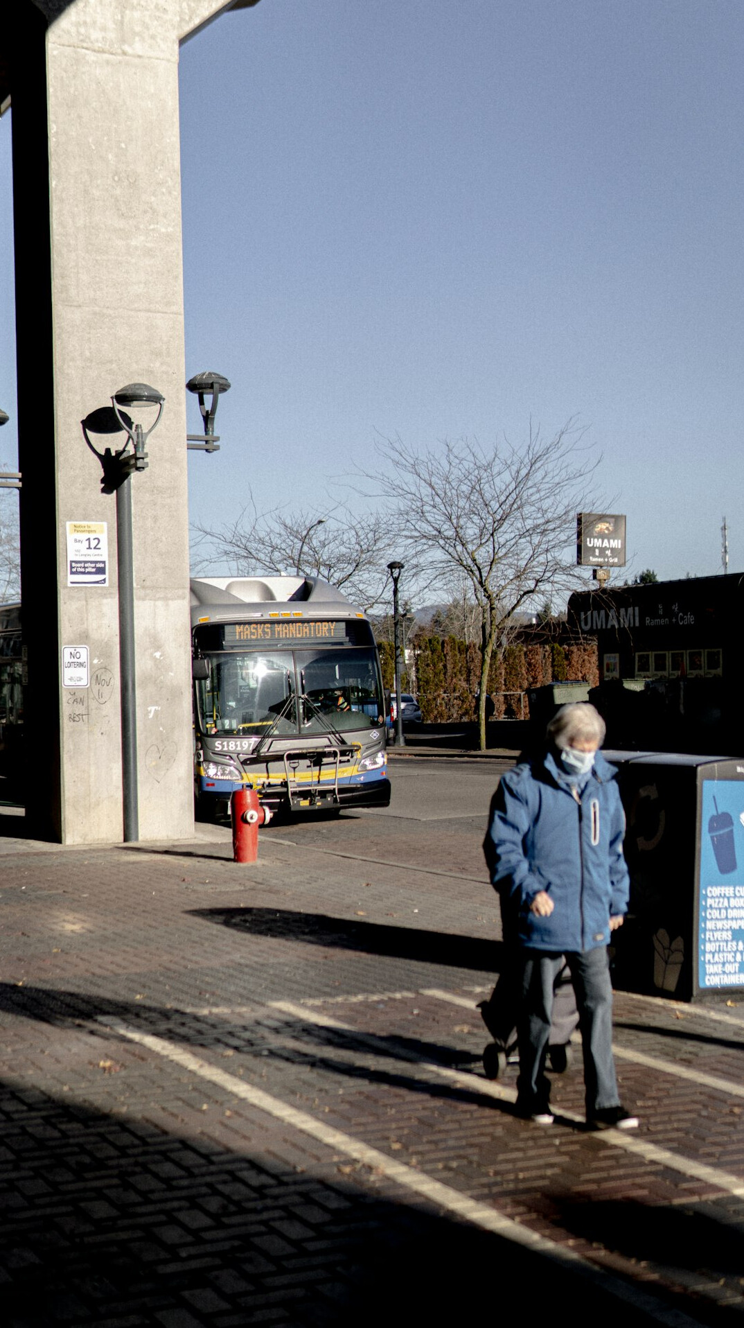 elderly woman waiting at bus stop
